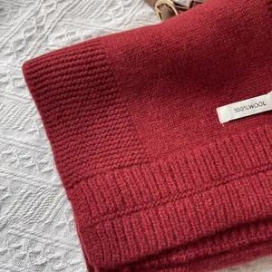 Detalle de bufanda de lana 100% pura que muestra el tejido de punto y la etiqueta