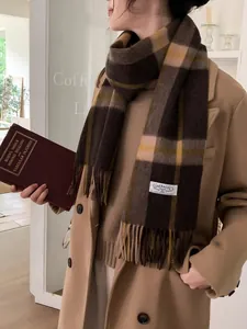 Detail of vintage plaid cashmere scarf with soft fringes and brand logo tag