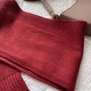 Detalle de cerca de bufanda de lana roja con textura de punto de calidad y borde acanalado
