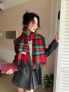 Close-up of red tartan plaid wool scarf with classic tassels and product label detail