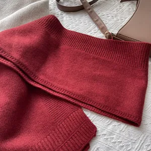 Textura detallada de bufanda de lana rojo oscuro con bordes acanalados y punto