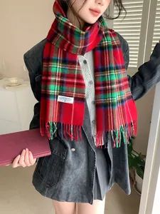 Detail of red and green plaid wool scarf with fringe and classic brand label