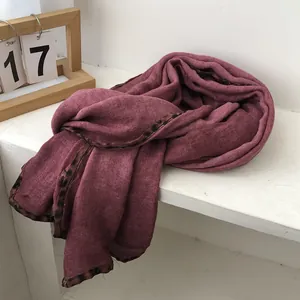 Detail of burgundy scarf featuring a stylish leopard print border and soft linen texture