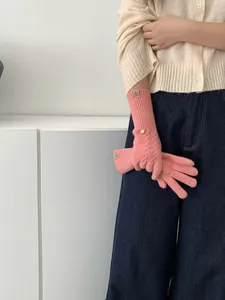 Detail of pink cable knit glove with ribbed cuff and elegant logo label on the wrist