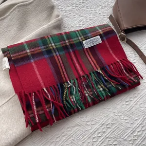 Detail view of colorful plaid wool scarf texture with fringe and brand label