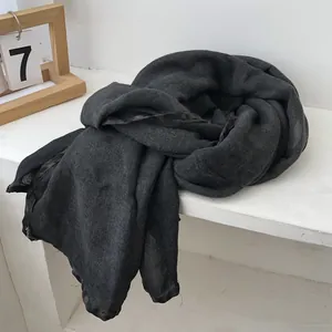 Detail of dark grey knit scarf featuring elegant black satin silk ribbon edging
