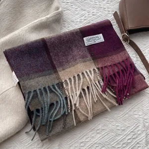 Detail eines Wollschals mit Karomuster, Twill-Struktur und Logo-Etikett in Lila-Tönen