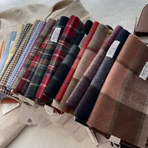 Detail of 100% wool scarves featuring classic plaid and houndstooth patterns in winter tones