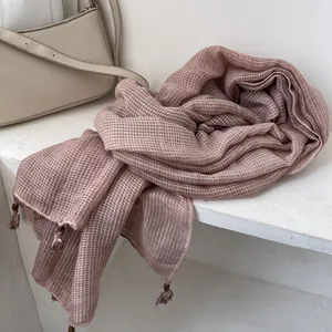 Dettaglio sciarpa in cotone rosa con trama a nido d'ape ed eleganti nappe con frange