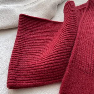 Makro-Detail von dunkelrotem Strickschal mit Rippenmuster aus dicker warmer Wolle