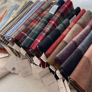 Close-up of 100% wool scarves showing various plaid patterns and soft fabric textures