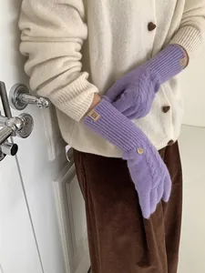 Detail of lavender cable knit wool glove featuring golden button and leather logo patch