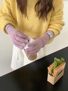 Close-up of taro purple knitted touch-screen gloves with ribbed cuffs and woven brand tag