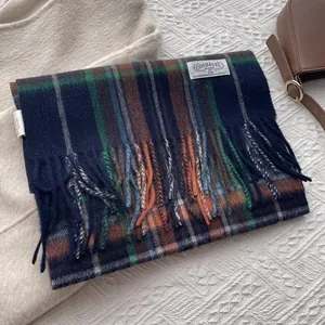 Detailed close-up of wool plaid scarf with navy and brown checkers and soft tassels