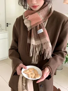 Nahaufnahme des schweren Wollschals mit klassischem violett-braunem Karomuster und Fransen