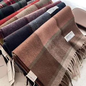 Detailed close-up of wool scarves featuring assorted plaid patterns and fringe textures