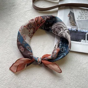 Detail eines Baumwoll-Bandanas mit Paisley-Muster gefaltet neben Modemagazin