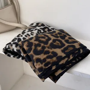 Detailed close-up of thick leopard print scarves with vertical knit texture in dual colors