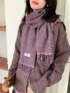 Close-up of purple houndstooth wool scarf with fine fringe detail and woven brand label