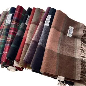 Stack of colorful 100% wool scarves with classic British plaid patterns and long tassels