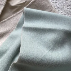Detailed texture of high-quality 100% wool scarves in mint green and beige tones