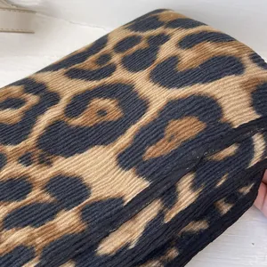 Close-up detail of leopard print scarf fabric showing vertical knit texture and patterns