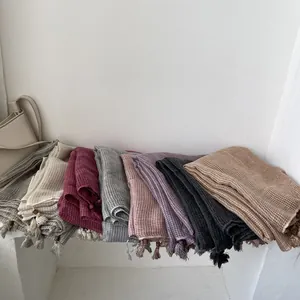 Collezione di sciarpe a quadri in cotone e lino con nappe in rilievo in legno e lunghi scialli