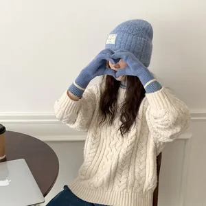 Sky blue touchscreen knit gloves paired with matching winter beanie and cable knit sweater