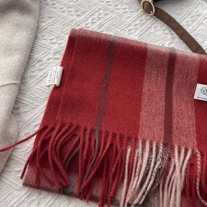 Detail of red and brown plaid cashmere scarf with fringes and authentic wash tags