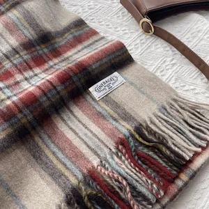 Close-up of wool blend checkered scarf with classic fringe and white woven brand label