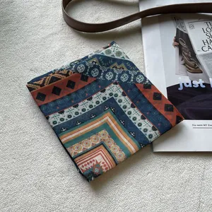 Detail eines Baumwolltuchs im Boho-Stil mit geometrischen Mustern auf weichem Hintergrund