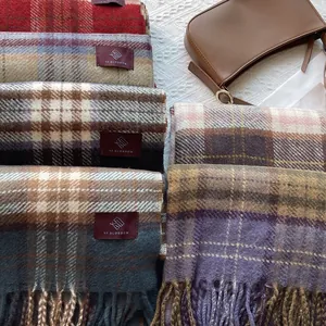Close-up of thick plaid scarves with fringes and brand labels in various retro colors