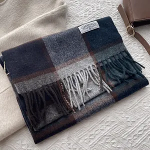Detailaufnahme eines dicken Wollschals mit blau-braunem Karomuster und Fransenrand