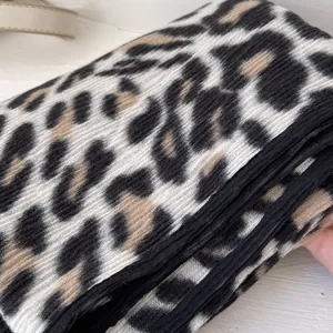 Detailed view of leopard print scarf featuring thick soft fabric and black ribbed edges