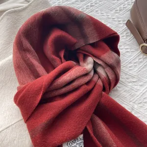 Detail of red gradient plaid cashmere scarf with soft texture and classic woven label