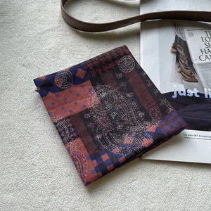Detail eines Vintage-Baumwollschals mit Paisley- und Hahnentrittmuster und Requisiten