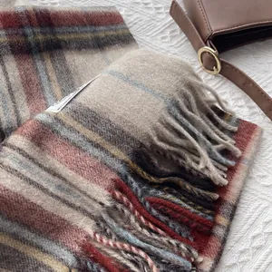Detail shot of the vintage plaid wool scarf with tassel edges and soft fabric texture