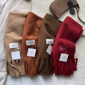 Flat lay of colorful wool scarves with fringes and brand labels in autumn fashion setting