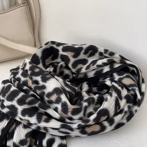 Detail of leopard print scarf with black trim showing soft ribbed texture and pattern
