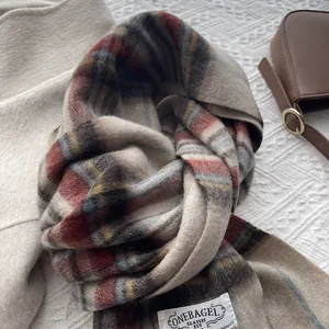 Detailed texture of plaid wool scarf with red and blue stripes and a brand label