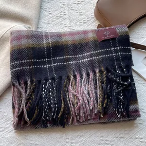 Close-up of vintage plaid scarf with fringed edges and branded woven label