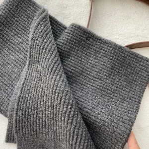 Detail eines dunkelgrauen, dick gerippten Strickschals mit hochwertiger Wollstruktur