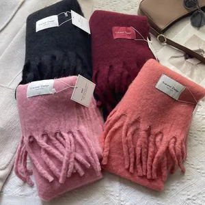 Detail of wool-like winter scarves with long tassels in multiple fashion colors
