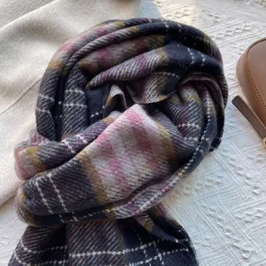 Close-up detail of soft purple plaid knit scarf with thick winter texture and fringe