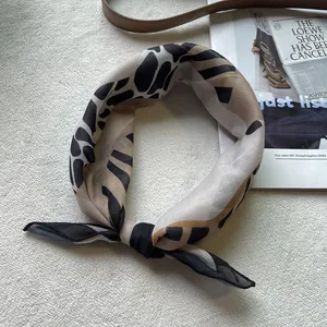 Detailansicht eines 58cm Baumwoll-Bandanas mit Leopardenmuster auf einem Magazin