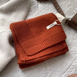 Detalle de una bufanda de 100% lana pura en color naranja con tejido de punto fino