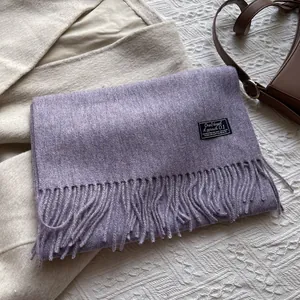 Close-up of lilac pure wool scarf with soft tassel detail and minimalist woven label