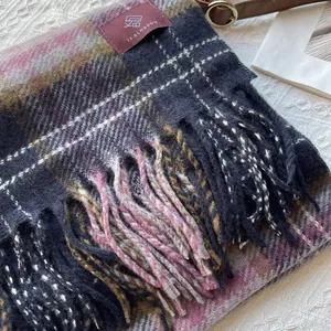 Detail view of pink and yellow vintage plaid scarf with handmade long tassels