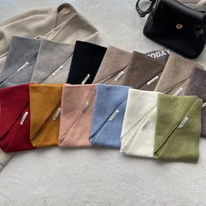 Vue à plat de foulards triangulaires en maille en dix coloris, dont beige et gris