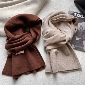 Close-up of 100% wool scarves showing fine knit texture and authentic composition tags